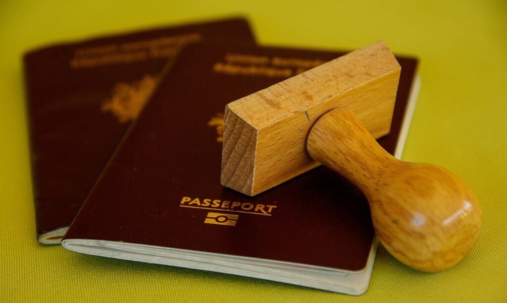 Wooden official stamp resting on passports, representing approvals and registration