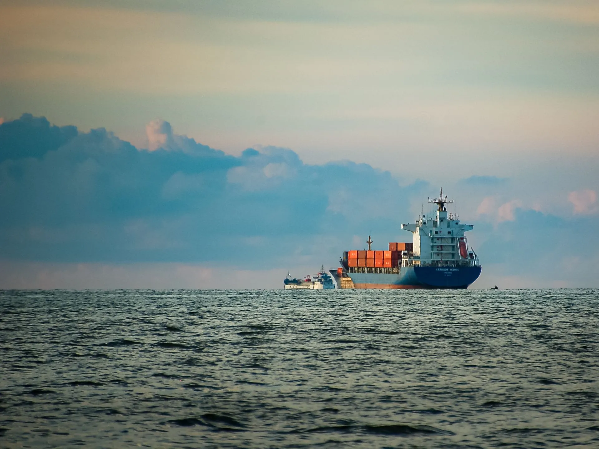 Container ship sailing across the open sea at dusk