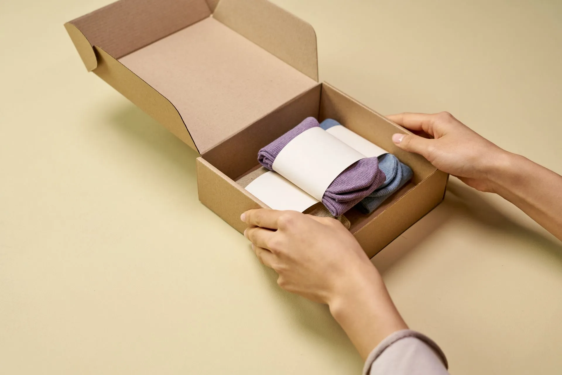 Person packing folded products into a cardboard box for export