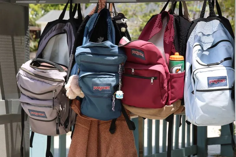 Colourful backpacks hanging on hooks